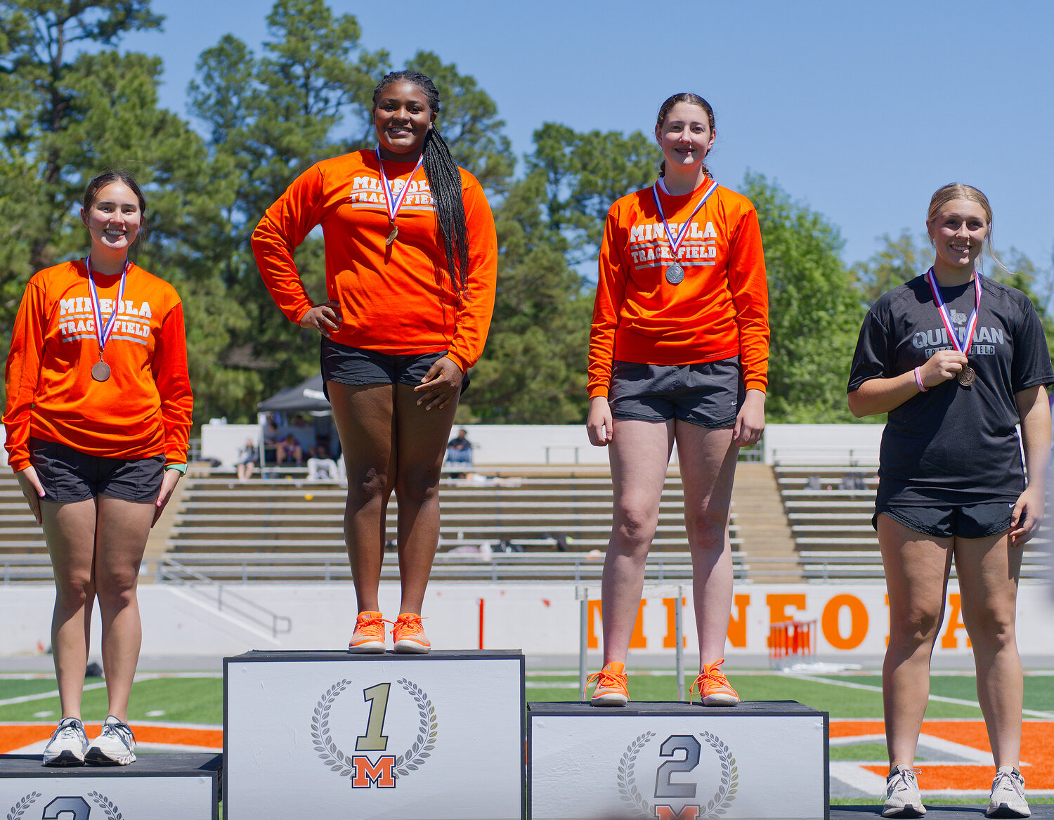 Left to right, Makena Quiambao, Zion Olajide, Callie Black and Annabelle Popek show off their newly acquired hardware. Olajide, Black and Quiambao swept the top three spots in the discus. Olajide threw 91 feet, with both of her teammates challenging that throw. Quitman's Popek claimed the fourth spot and an area meet berth. [see more speed and strength on display]